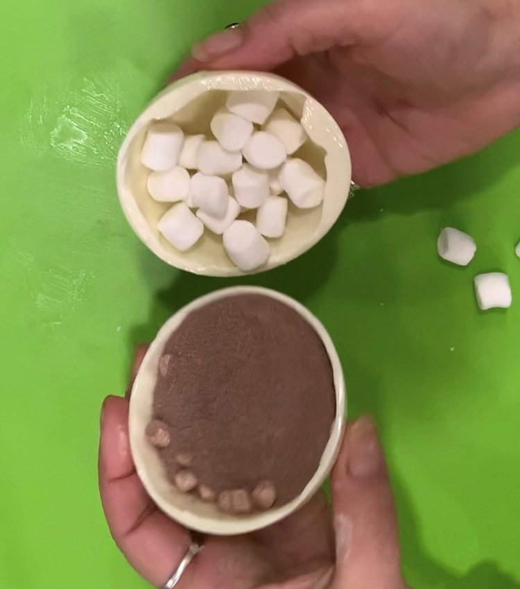 Fill one sphere with hot chocolate and the other with mini-marshmallows. Heat the edge of a sphere and assemble.